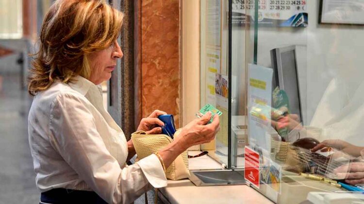 Mujer de 65 años solicitando la Tarjeta Andalucía Junta 65 en una ventanilla pública para acceder a descuentos en salud, ocio y turismo