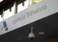 Letrero de la Agencia Tributaria con cámara de seguridad, organismo que sanciona el retraso en la declaración de la Renta
