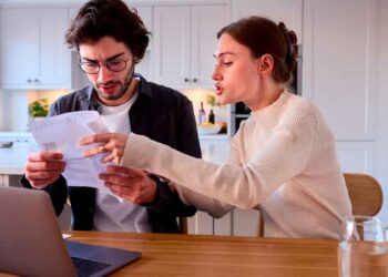 Pareja revisa documentos sobre la deducción del IRPF por alquiler tras un depósito de fianza no realizado