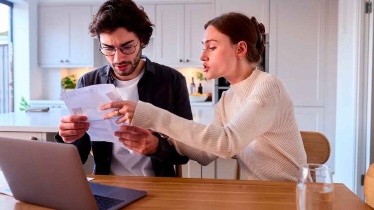 Pareja revisa documentos sobre la deducción del IRPF por alquiler tras un depósito de fianza no realizado