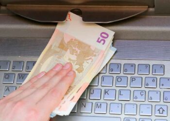 Mano retirando billetes de 50 euros en un cajero automático, acción que Hacienda puede sancionar con hasta 150 000 euros