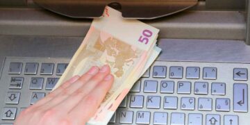Mano retirando billetes de 50 euros en un cajero automático, acción que Hacienda puede sancionar con hasta 150 000 euros