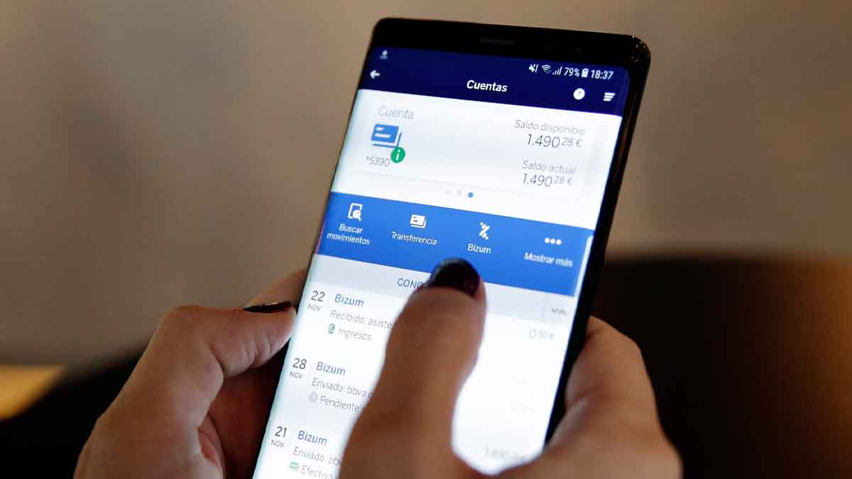 Persona usando Bizum en el móvil para realizar una transferencia bancaria