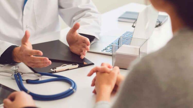 Médico evaluando a paciente durante consulta para solicitud de incapacidad permanente