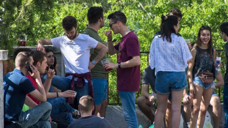 Grupo de jóvenes españoles reunidos al aire libre, reflejo de la generación con menos capacidad de ahorro que sus padres