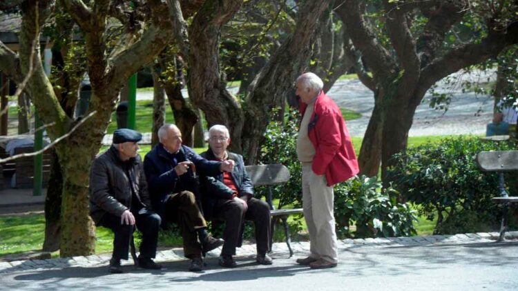 Grupo de jubilados conversando en un parque, representando la situación de pensiones por debajo del salario mínimo en España