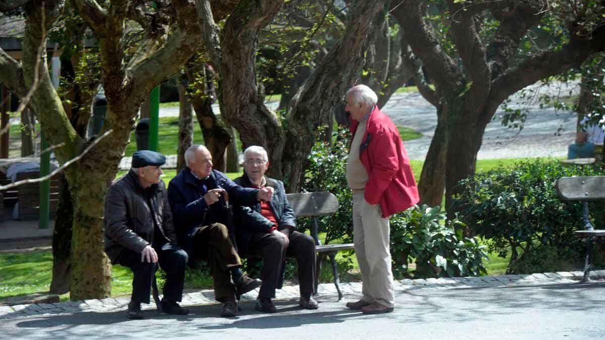 Grupo de jubilados conversando en un parque, representando la situación de pensiones por debajo del salario mínimo en España
