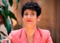 Mujer sonriente con blazer rosa que representa a las madres que pueden sumar hasta 5 años de cotización por maternidad