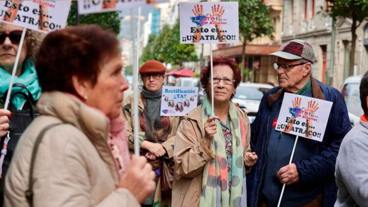 Mutualistas con incapacidad absoluta protestan en la calle con carteles que exigen a Hacienda la devolución del IRPF.