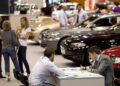 Personas comparando precios y modelos en concesionario de coches nuevos en 2025