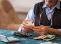 Pensionista contando billetes de euro tras recibir la paga extra de verano 2025 con subida incluida