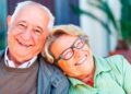 Pareja de jubilados sonrientes tras solicitar online el complemento de brecha de género que eleva su pensión más de 100 € al mes