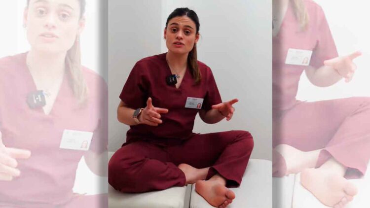 Podóloga en su consulta, sentada con uniforme burdeos y pies descalzos, explicando tres hábitos diarios que dañan la salud podal