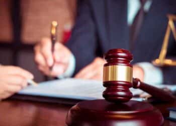 Mazo del juez sobre una mesa mientras un letrado firma la sentencia que otorga incapacidad absoluta y pensión de 2.000 € a una profesora