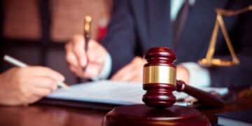 Mazo del juez sobre una mesa mientras un letrado firma la sentencia que otorga incapacidad absoluta y pensión de 2.000 € a una profesora