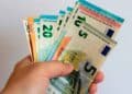 Mano sujetando varios billetes de euro, símbolo de transferencia de dinero entre familiares y posibles sanciones de Hacienda