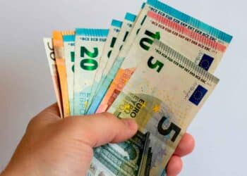 Mano sujetando varios billetes de euro, símbolo de transferencia de dinero entre familiares y posibles sanciones de Hacienda