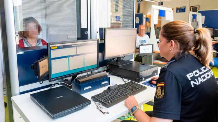Agente de la Policía Nacional gestionando la renovación gratuita del DNI en una oficina de documentación