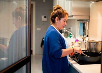 Mujer trabaja como empleada de hogar en la cocina, colectivo que podrá cobrar el subsidio SEPE para mayores de 52 años sin cotización completa