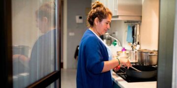 Mujer trabaja como empleada de hogar en la cocina, colectivo que podrá cobrar el subsidio SEPE para mayores de 52 años sin cotización completa