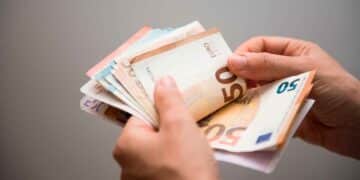 Manos contando billetes de 50 € que ilustran la ayuda del SEPE de 570 € mensuales por cotizaciones insuficientes