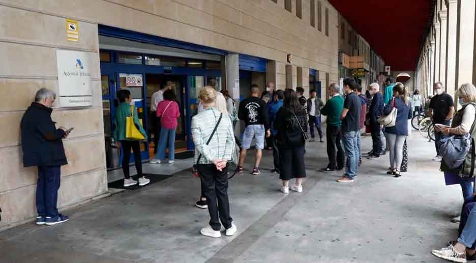 Contribuyentes hacen cola ante una oficina de la Agencia Tributaria para aclarar su declaración de la renta tras detectar suplantación de identidad en juegos online
