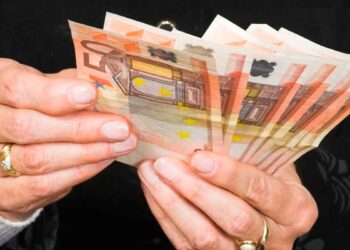 Manos de jubilada contando billetes de 50 €, símbolo de la pensión media de 1.505 € alcanzada en mayo