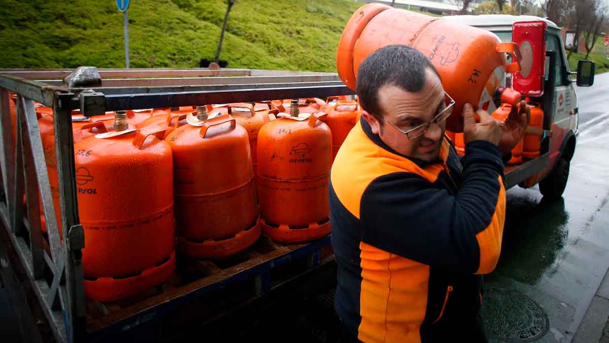 Repartidor cargando bombona de butano Repsol en una calle, tras la subida de precio en mayo de 2025