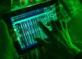 Mano manipulando tablet con datos en pantalla, simulando ciberestafa bancaria digital