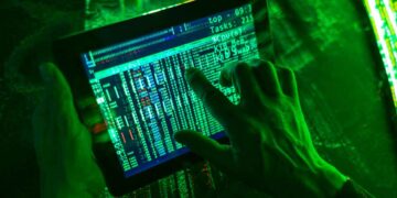 Mano manipulando tablet con datos en pantalla, simulando ciberestafa bancaria digital