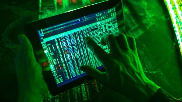 Mano manipulando tablet con datos en pantalla, simulando ciberestafa bancaria digital