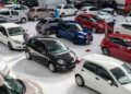 Vista de concesionario de coches de segunda mano con varios vehículos; alerta sobre estafas de cuentakilómetros, robos e inundaciones