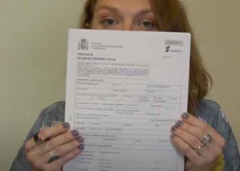 Mujer muestra formulario solicitud Ingreso Mínimo Vital para comprobar estado aprobado, denegado o en trámite