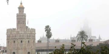 Torre del Oro y la Giralda de Sevilla bajo densa niebla durante el episodio de viento y lluvia del 6 de mayo de 2025 en Andalucía