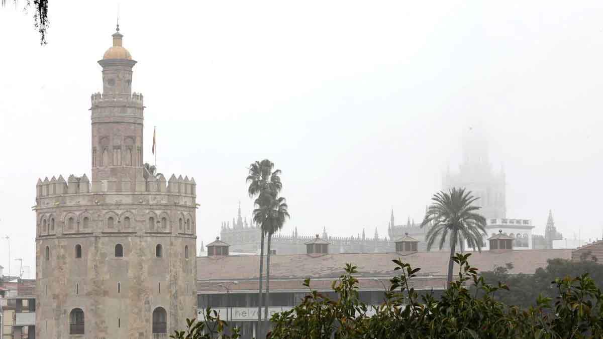 Torre del Oro y la Giralda de Sevilla bajo densa niebla durante el episodio de viento y lluvia del 6 de mayo de 2025 en Andalucía