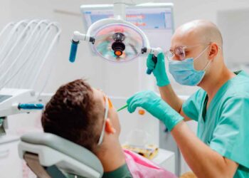 Dentista revisa a paciente en consulta, ejemplo de la atención dental gratuita del plan de la Seguridad Social 2025.