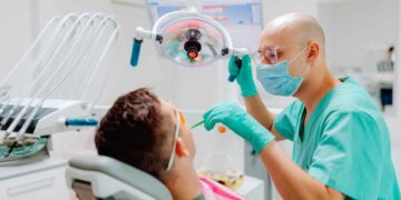 Dentista revisa a paciente en consulta, ejemplo de la atención dental gratuita del plan de la Seguridad Social 2025.