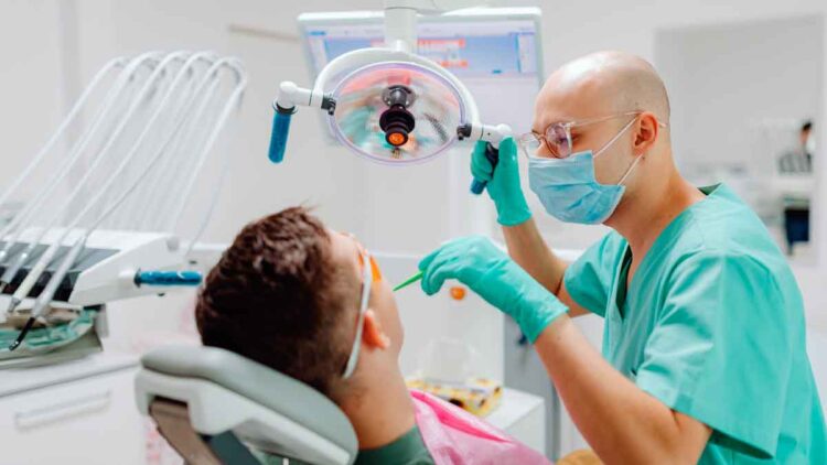 Dentista revisa a paciente en consulta, ejemplo de la atención dental gratuita del plan de la Seguridad Social 2025.