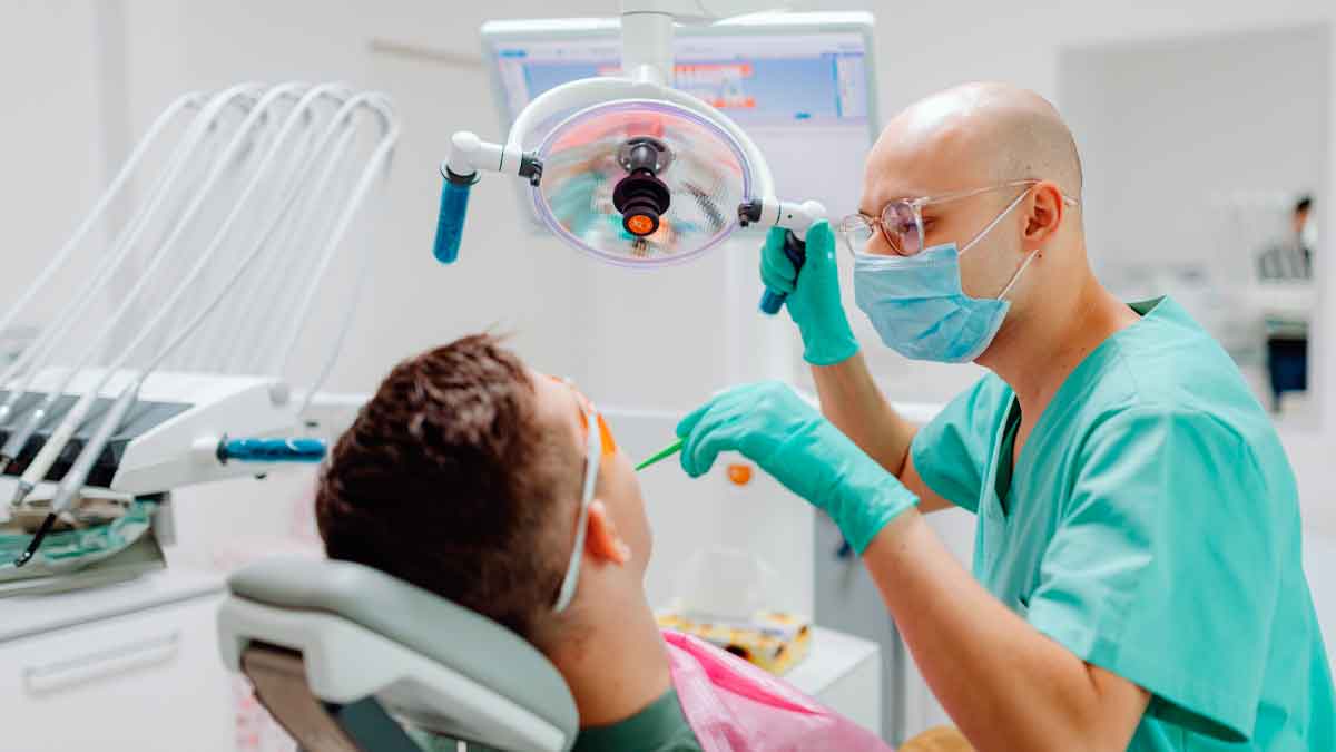 Dentista revisa a paciente en consulta, ejemplo de la atención dental gratuita del plan de la Seguridad Social 2025.