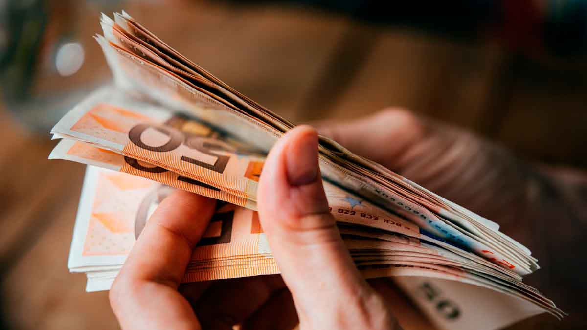 Persona contando billetes en euros, simbolizando ayudas económicas y rentas mínimas en Andalucía