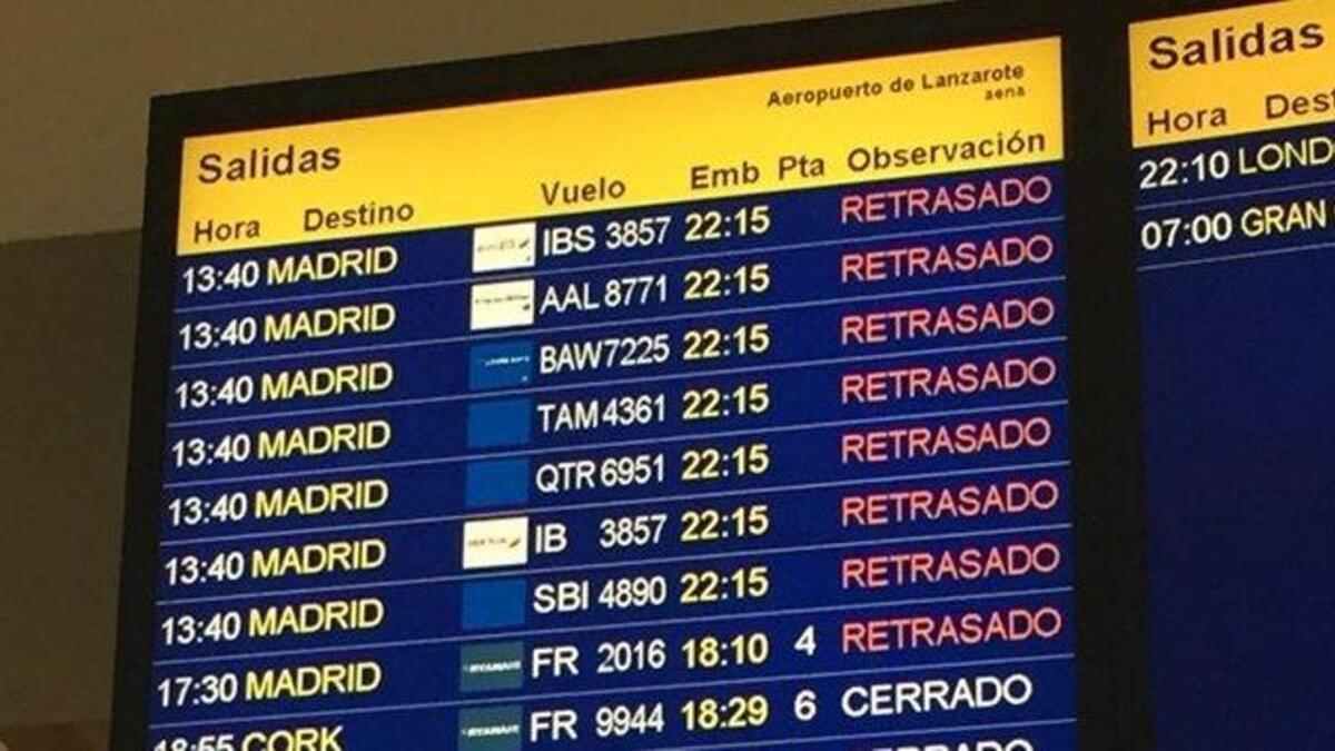 Panel de salidas del Aeropuerto de Lanzarote con vuelos a Madrid retrasados; cambio de fecha y derecho a indemnización hasta 600 €.