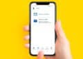 Mano sujetando un smartphone con la app de la Agencia Tributaria abierta en “Avisos personales” para la campaña Renta 2025