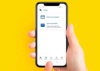 Mano sujetando un smartphone con la app de la Agencia Tributaria abierta en “Avisos personales” para la campaña Renta 2025