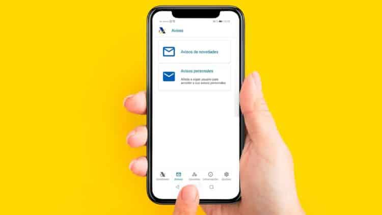 Mano sujetando un smartphone con la app de la Agencia Tributaria abierta en “Avisos personales” para la campaña Renta 2025