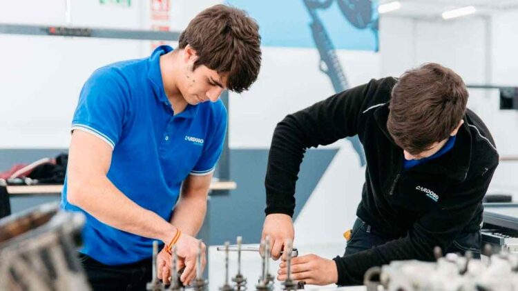 Estudiantes de Cardoso Academy practicando mecánica en taller durante su formación profesional en Sevilla