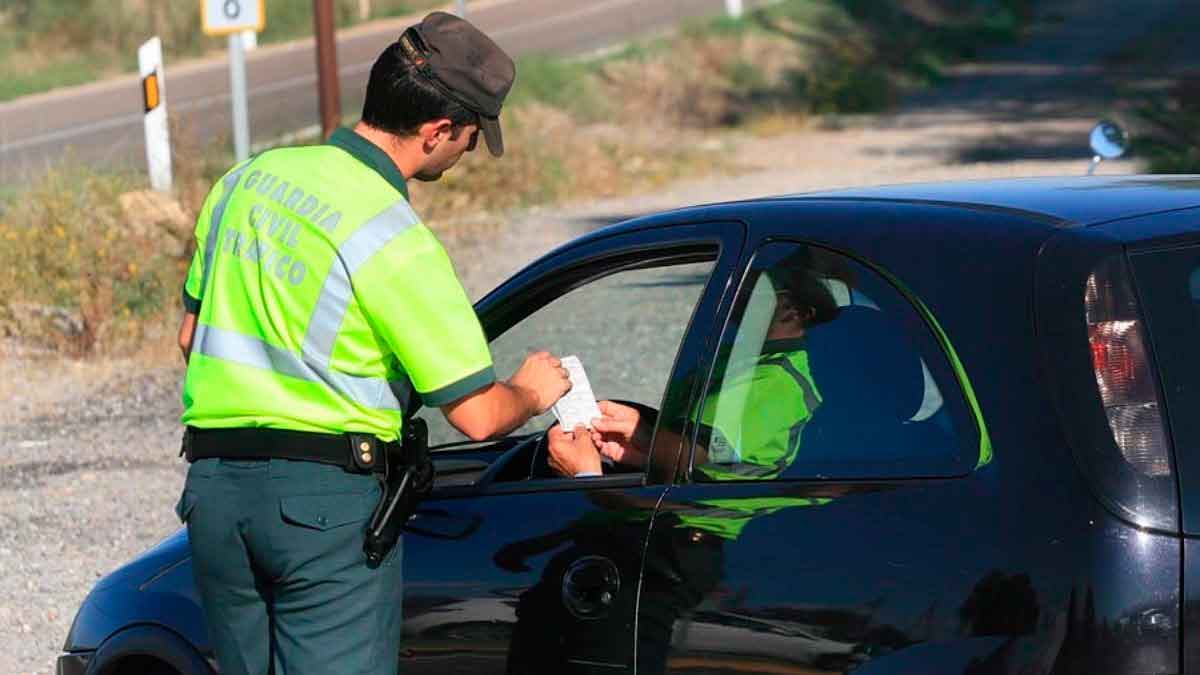 Agente de la Guardia Civil Tráfico imponiendo multa de 400 € a conductor por llevar la bola de remolque no homologada