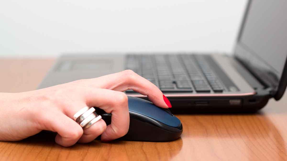 Mano de usuario haciendo clic con el ratón del portátil, representando factura sorpresa de Google por 9.000 euros