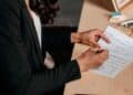 Mujer heredera firmando la declaración de la Renta de un familiar fallecido en una mesa de oficina