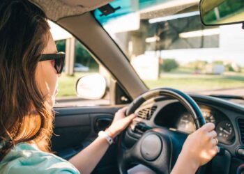 Mujer conduciendo un coche al atardecer, ejemplo de vehículo de gasolina, diésel o eléctrico y su vida útil sin averías
