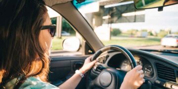 Mujer conduciendo un coche al atardecer, ejemplo de vehículo de gasolina, diésel o eléctrico y su vida útil sin averías